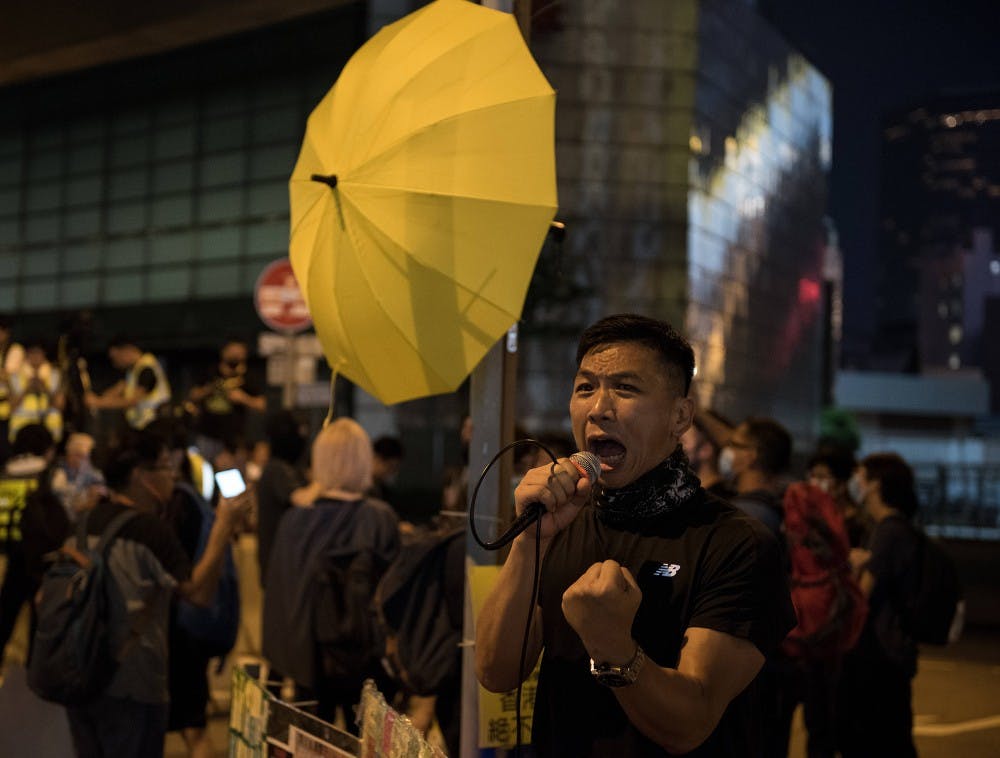 香港一名抗议者在示威中高喊各种口号。示威者举行反独裁集会，纪念2014年“雨伞运动”开始五周年。数千名抗议者和平集会，但抗议者和警察之间的小规模冲突在夜间升级，导致警方采取了驱散行动。
