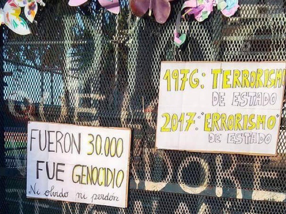 Signs are affixed to a fence in La Plaza de Mayo during a protest on the anniversary of the 1976 military coup. The military government has forcibly disappeared over 36,000 workers and activists.&nbsp;