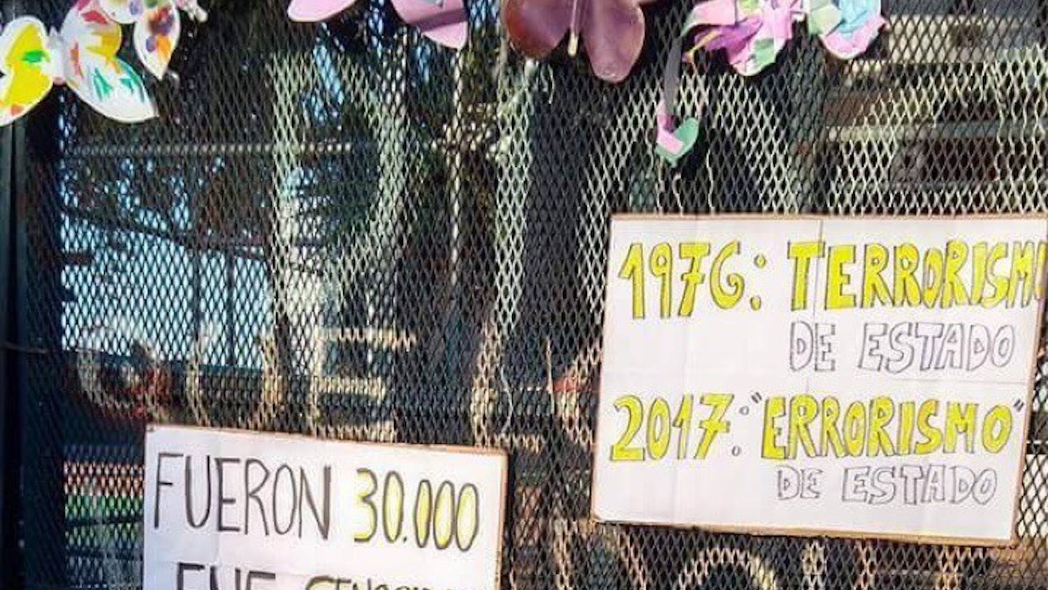 Signs are affixed to a fence in La Plaza de Mayo during a protest on the anniversary of the 1976 military coup. The military government has forcibly disappeared over 36,000 workers and activists. 