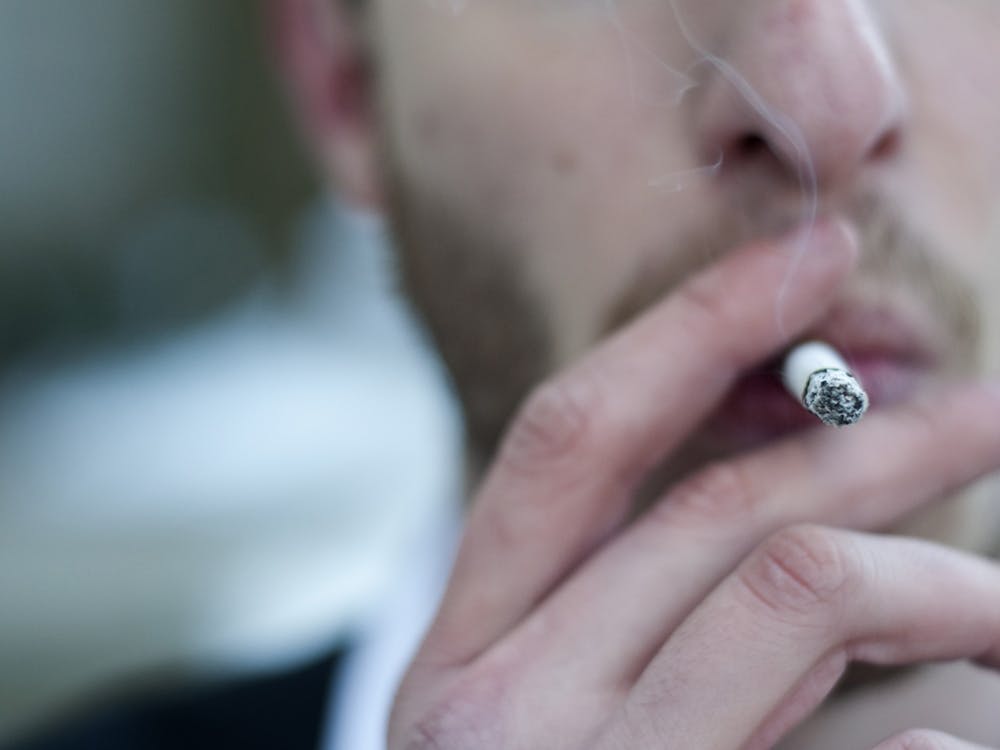 A man smokes a cigarette. Indiana ranks 10th in the U.S. for the number of adults who smoke at 19.20% of the population, according to an August report from NiceRx.