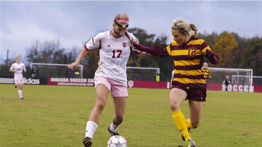 IU sophomore midfielder Jordan Woolums goes moves the ball upfield against Minnesota senior midfielder/defender Marissa Price on Friday at Armstrong Stadium. The IU women’s soccer team wore pink shorts as part of the athletic department’s Think Pink campaign to raise breast cancer awareness.