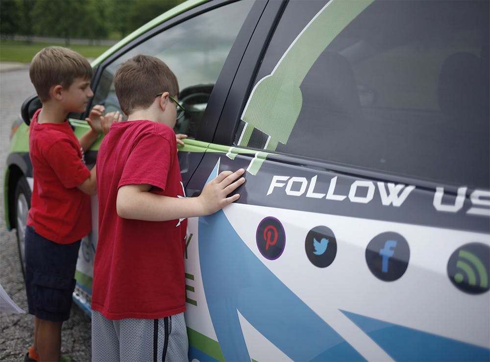 从左边，二级学生Levi Schroeder和Mason Powwell在Marlin小学周三周三看着Energymobile。这辆车全天访问了三所当地学校，以促进对学生的可持续性。