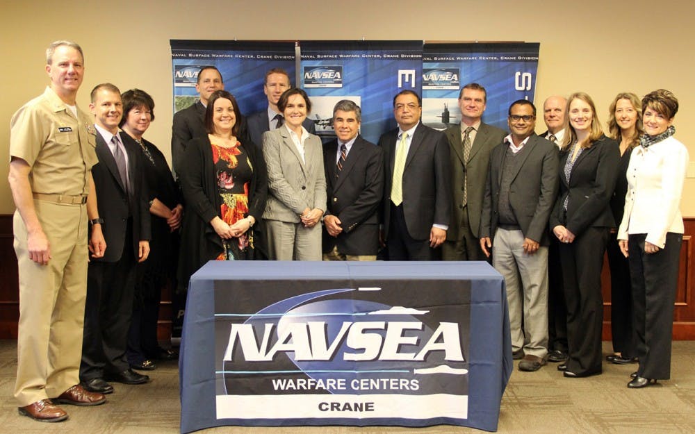 Navy personnel and IU School of Informatics faculty pose for a photo after signing an agreement to help integrate smart technology from IU into the naval defenses.