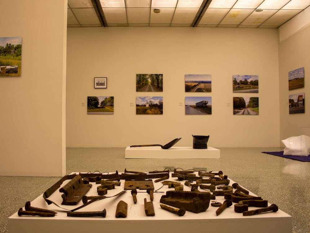 An installation by Betsy Stirratt sits in the foreground, and photos by Richard Koenig hang in the background Tuesday at the Grunwald Gallery of Art. Koenig and Stirratt both have work being featured in Grunwald&#x27;s new exhibit, &quot;Hoosier Lifelines: Environmental and Social Change Along the Monon, 1847-2020.&quot;
