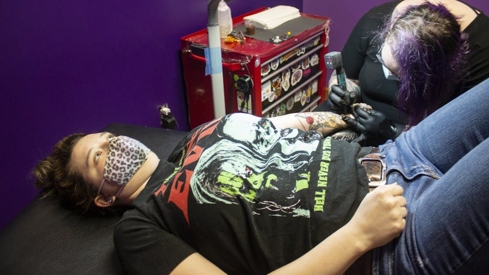 2月23日，纹身艺术家Kae Hutchens在布卢明顿的水晶月亮人体艺术中心为Kava Seek纹身。Hutchens就是商店'；他是个纹身艺术家，已经纹身15年了。