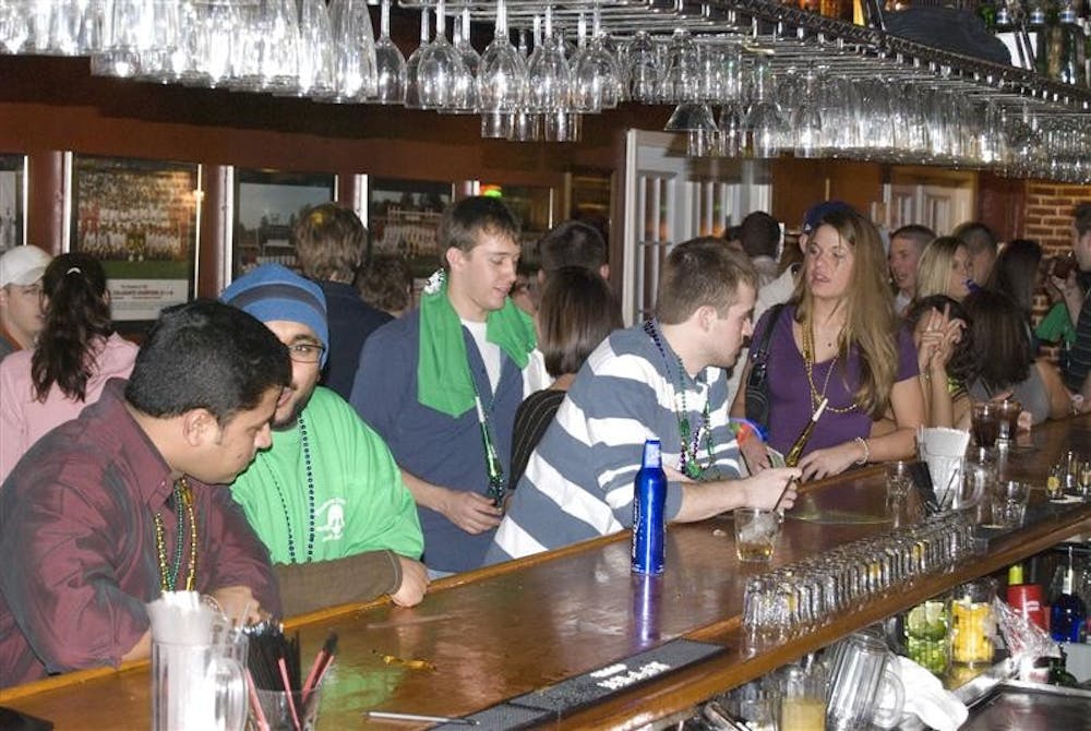 Patrons buy drinks and socialize at Kilroys Sports Bar on Walnut Avenue Tuesday evening.