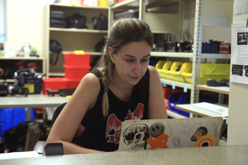 Senior Sophia Grimsgard works at the Media School equipment checkout window. All campus jobs pay at least $10.15 an hour and can increase based on a student’s relevant experience.&nbsp;