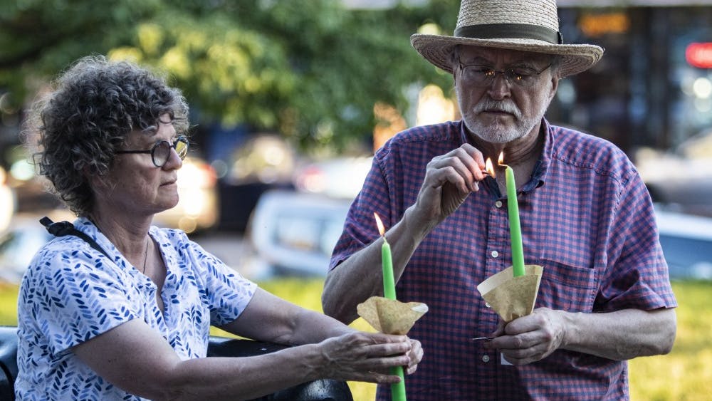 Bloomington residents Susan Schwibz and Roy Sillings light their candles before participating in the &quot;Lights for Liberty&quot; vigil July 12 in front of the Monroe County Courthouse. “You can’t treat people like this,” said Schwibz when talking about human detention centers in the United States.