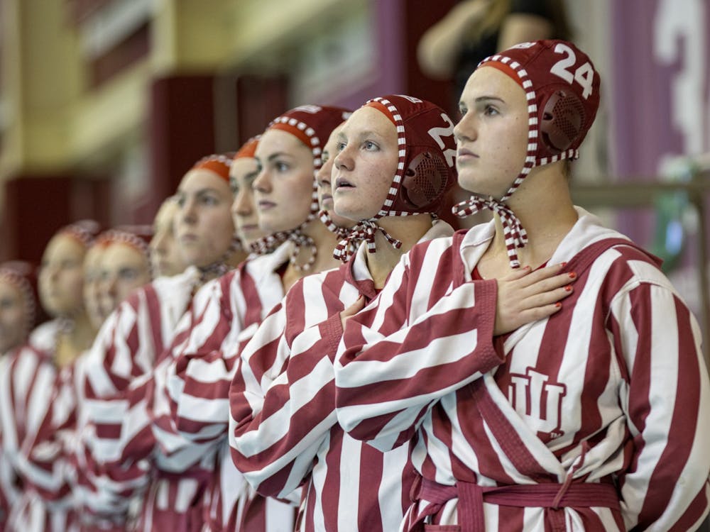 Freshman driver Grace Hathaway and the Indiana water polo team stand for the National Anthem on March 26, 2022, at the Counsilman Billingsley Aquatic Center. Indiana won both of its final two home games of the season on senior day Saturday.