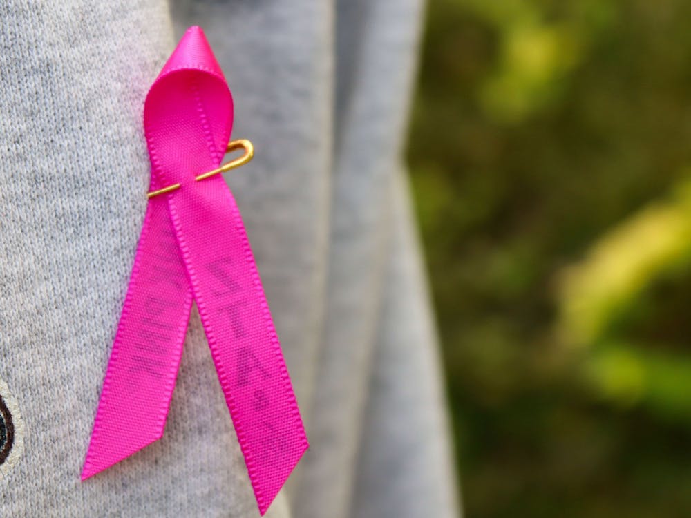 A breast cancer awareness ribbon is pinned to a woman's shirt Oct. 21, 2021. October is Breast Cancer Awareness Month.