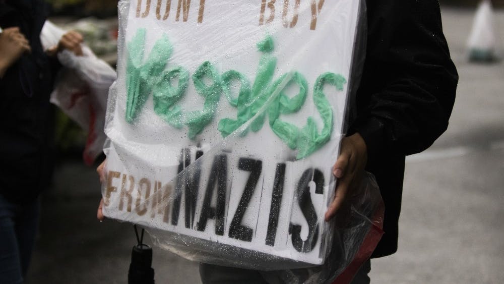 6月15日，在布鲁明顿农贸市场，一个人举着一个牌子。牌子上写着:“不要从纳粹那里买蔬菜。”