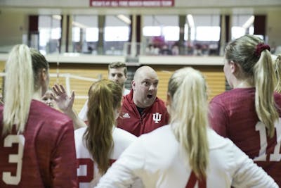 Women's volleyball head coach Steve Aird huddles the whole team after the second game at the Cream & Crimson scrimmage Aug. 18 in Assembly Hall. Aird brought in a top recruit in Emily Fitzner on Thursday.