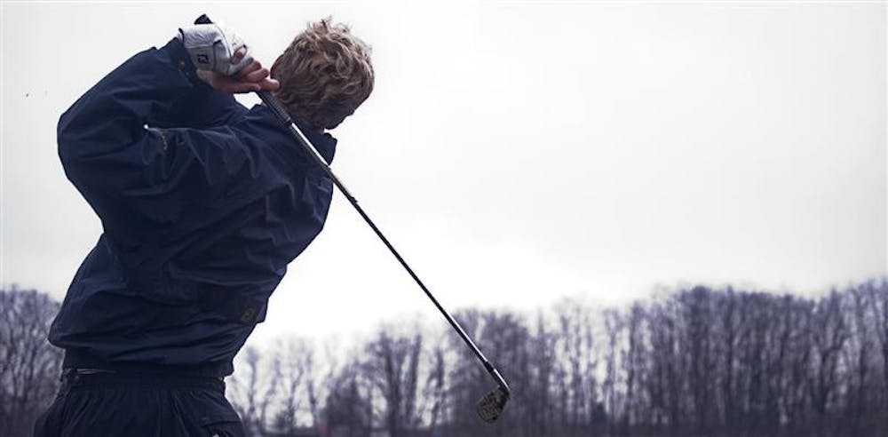 Senior Drew Allenspach tracks his shot during practice on Thursday afternoon at the IU Driving Range.