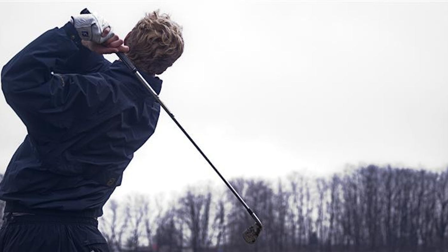 Senior Drew Allenspach tracks his shot during practice on Thursday afternoon at the IU Driving Range.
