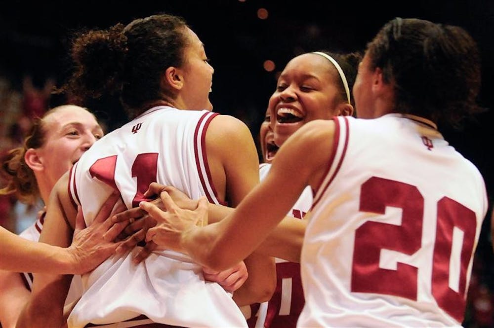 IU players rush to senior Whitney Thomas, left, after she hit a game winning shot with 0.2 seconds left during IU's 59-57 win against Dayton on Sunday at Assembly Hall.