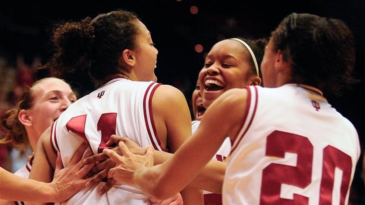 IU players rush to senior Whitney Thomas, left, after she hit a game winning shot with 0.2 seconds left during IU's 59-57 win against Dayton on Sunday at Assembly Hall.