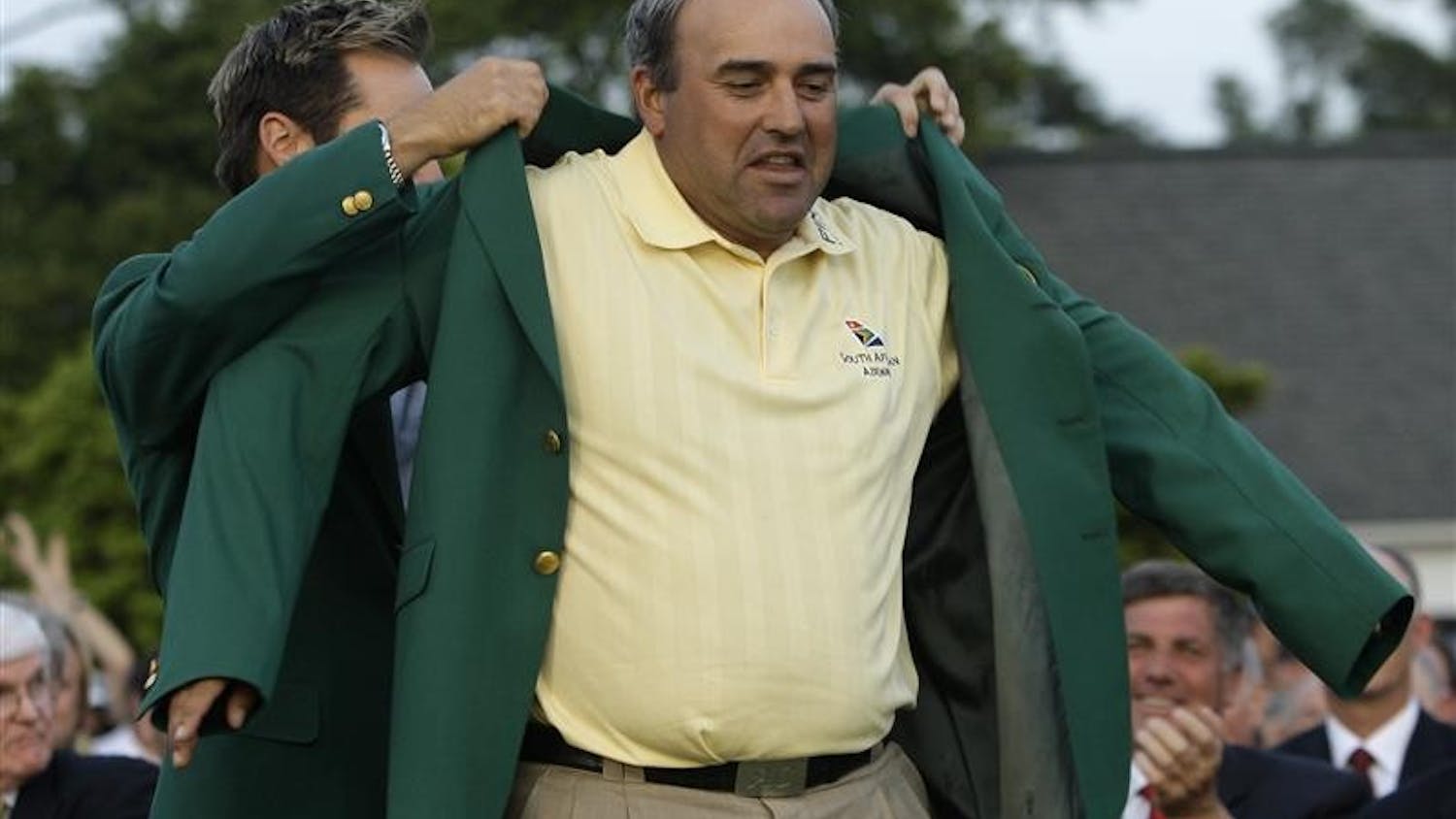 Former Masters' champion Trevor Immelman of South Africa helps 2009 Masters golf champion Angel Cabrera of Argentina with his Masters' green jacket at the Augusta National Golf Club in Augusta, Ga., Sunday, April 12, 2009.