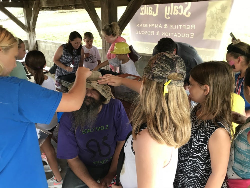 <p>People pet a snake on a man&#x27;s head at the 2018 Monroe County Fall Festival in Ellettsville, Indiana. Education Day at the 2019 festival is from 9 a.m. to 2 p.m. Friday at Marci Jane Lewis Park in Ellettsville.</p>