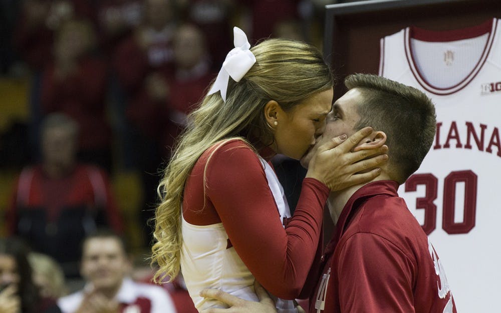 Senior Collin Hartman kisses his fiancee, senior Haley Daniel after proposing to her. Hartman successfully surprised her on their senior night.