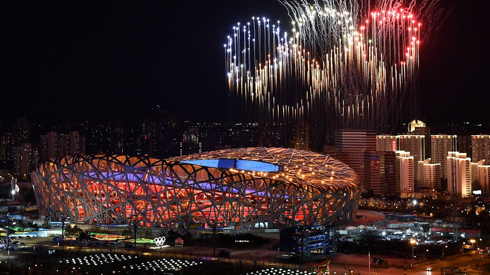 Fireworks in the shape of the Olympic rings go off Feb. 4, 2022, over the National Stadium during the opening ceremony of the Beijing 2022 Winter Olympic Games. Ellia Green, now the first Olympian to come out as a transgender man, appeared in the opening video shown at the Bingham Cup Summit addressing what it&#x27;s like to be a transgender athlete.