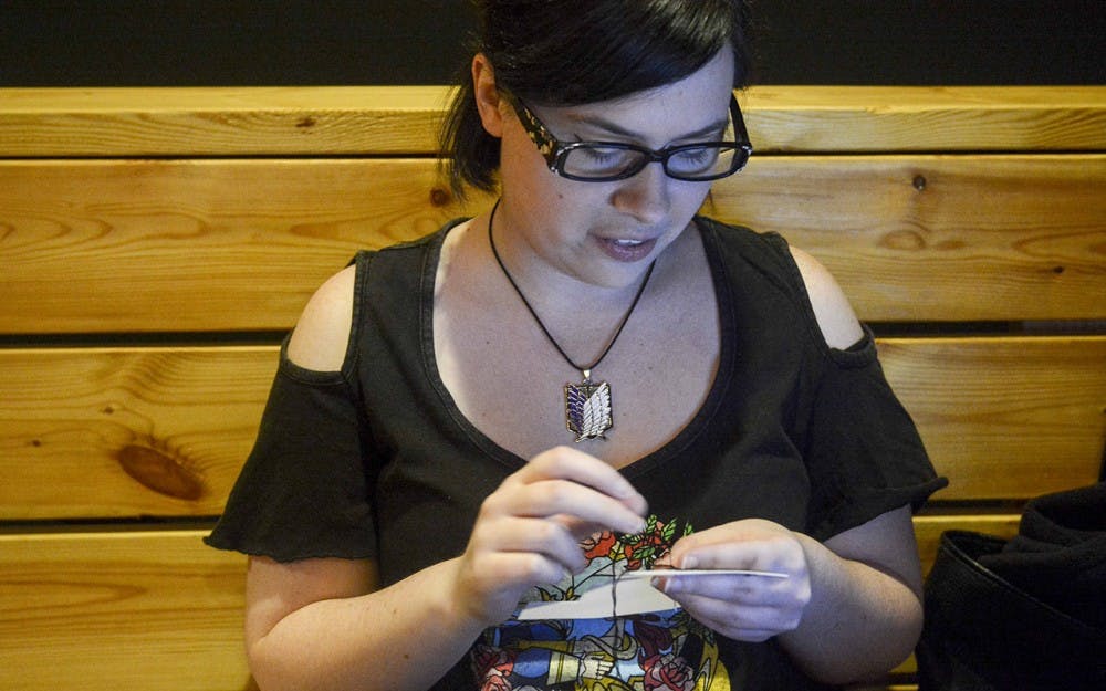 Abby bouen makes cross stitching in the Valentine's themed "Stitch & Bitch" event on Monday evening at Cardinal Spirits. 