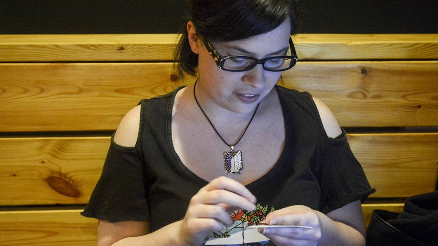 Abby bouen makes cross stitching in the Valentine's themed "Stitch & Bitch" event on Monday evening at Cardinal Spirits. 