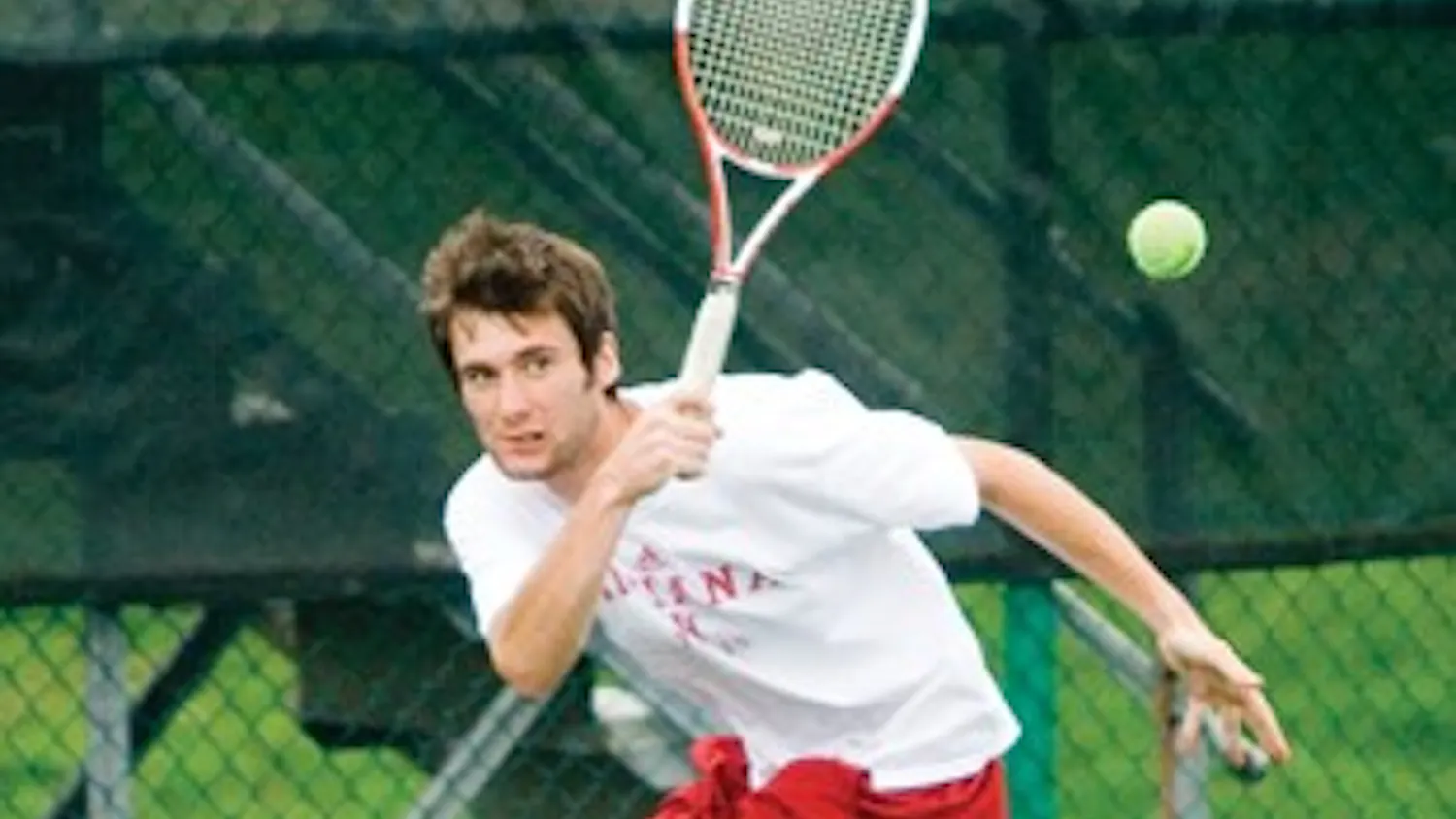 Junior Dara McLoughlin returns a shot against Michigan State at the IU Varsity tennis courts Saturday afternoon. McLoughlin won his singles match 6-3, 6-1.