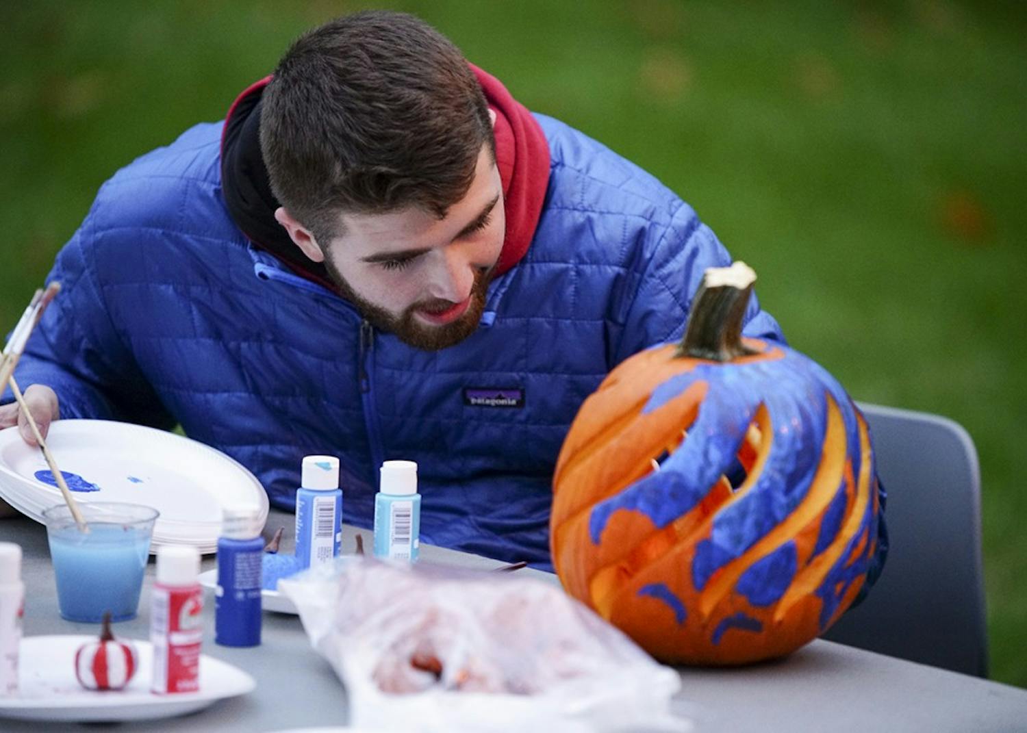 Freshman Tanner Graves decorates pumpkins while chatting with friends during Central’s Creepy Carnival Saturday evening outside of Teter Quadrangle. The event featured laser tag, free food catered by Residential Programs and Services Dining and an outdoor movie screening of the 1984 film Ghostbusters.