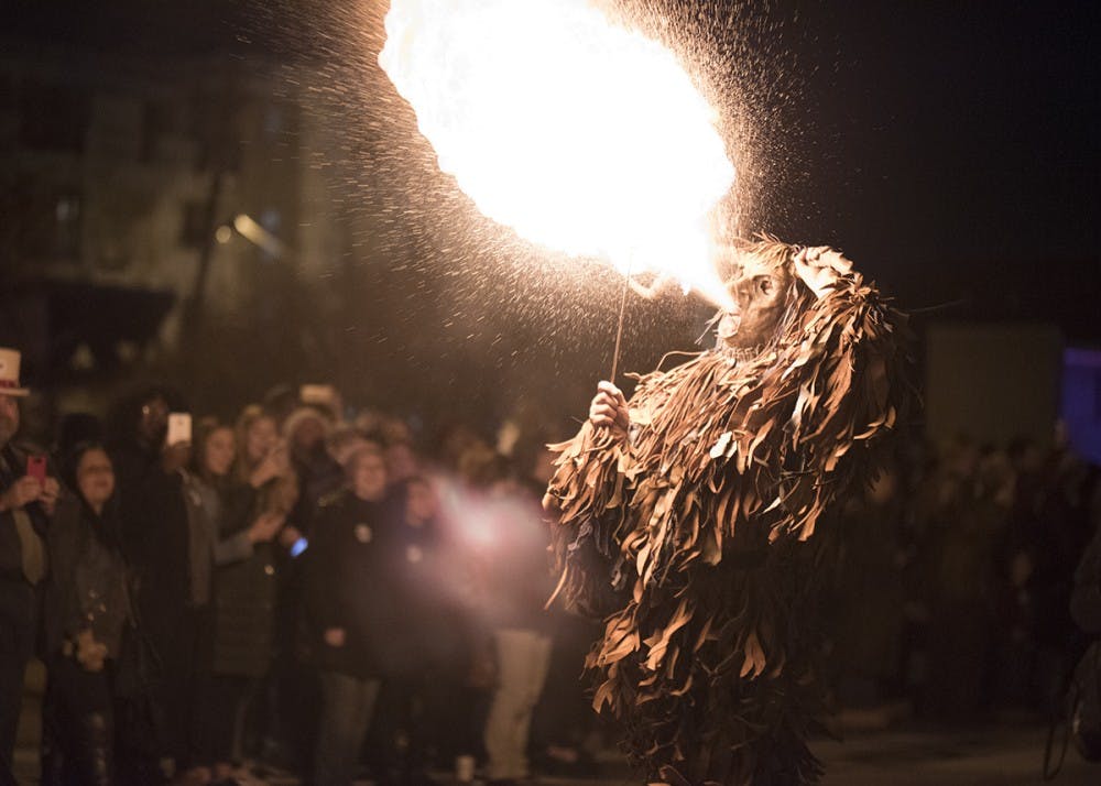 A person dressed as a Krampus spits fire at the Krampus Rampage and Bazaar in 2017. The rampage started with angels giving candy to children with "nice" stickers on and ended with the Krampus swatting children wearing "naughty" stickers with a bundle of sticks.&nbsp;