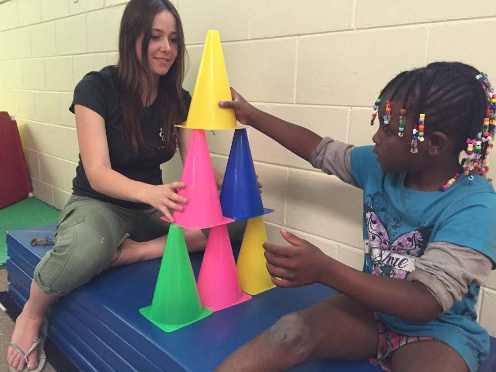 Madison Schlichter builds a tower with Destiny, one of the campers at Schlichter's Like a Lion summer camp. Schlichter started the nonprofit with friends in 2012.