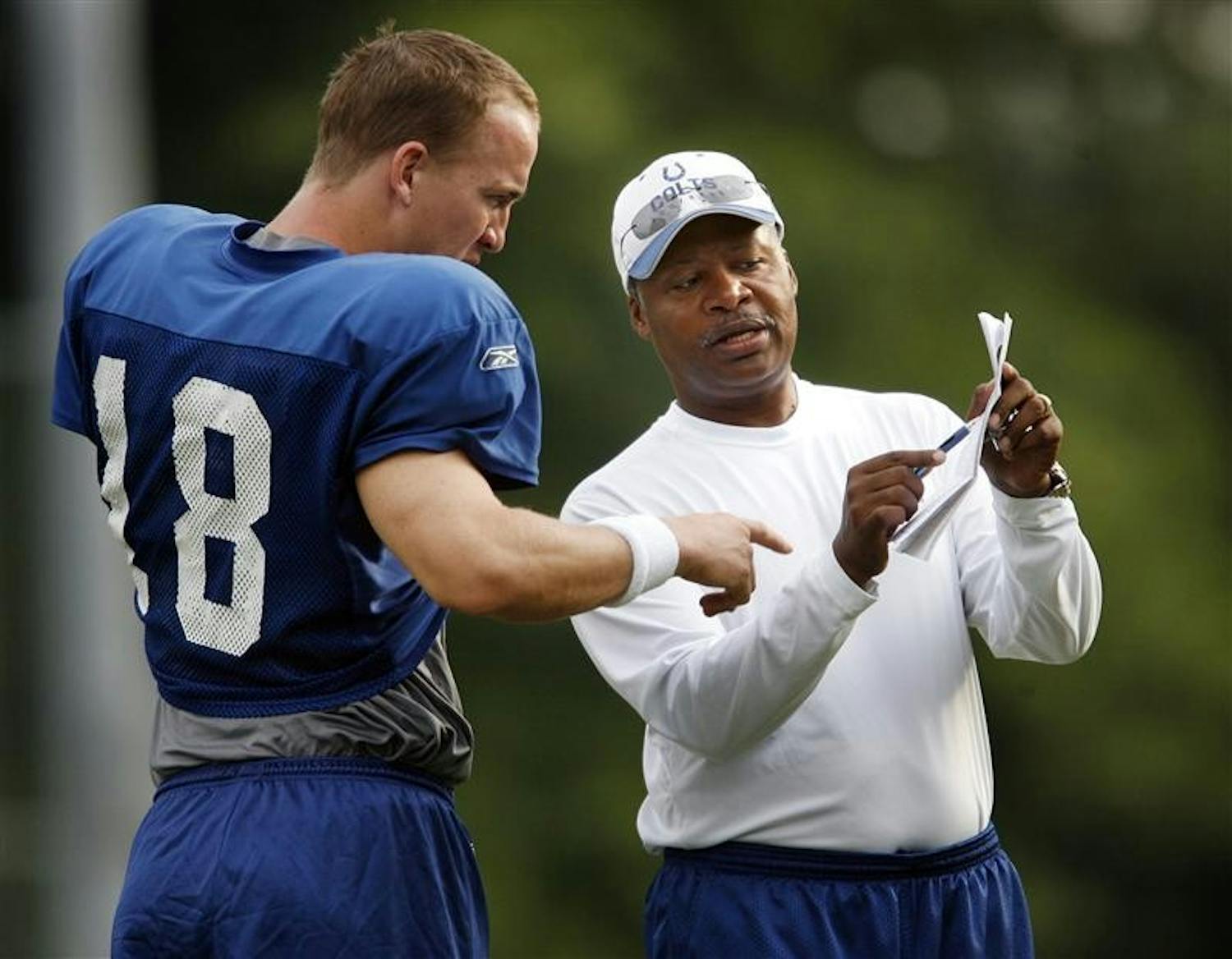 Indianapolis Colts assistant head coach and quarterbacks coach Jim Caldwell, right, talks some plays with Peyton Manning, left, during their practice Thursday afternoon at Rose-Hulman Institute of Technology in Terre Haute.