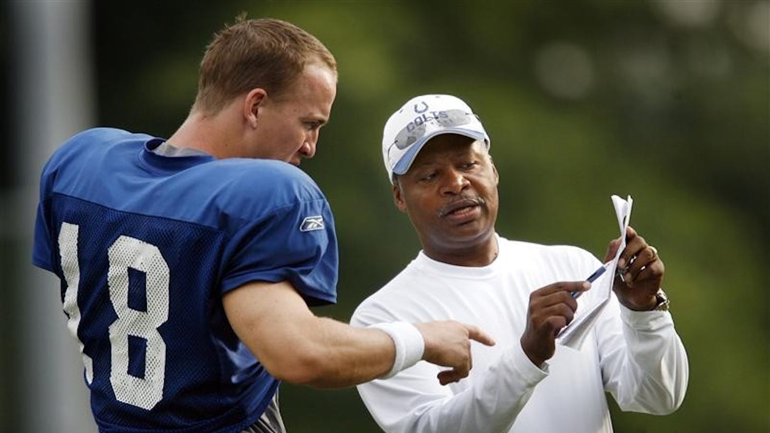 Indianapolis Colts assistant head coach and quarterbacks coach Jim Caldwell, right, talks some plays with Peyton Manning, left, during their practice Thursday afternoon at Rose-Hulman Institute of Technology in Terre Haute.