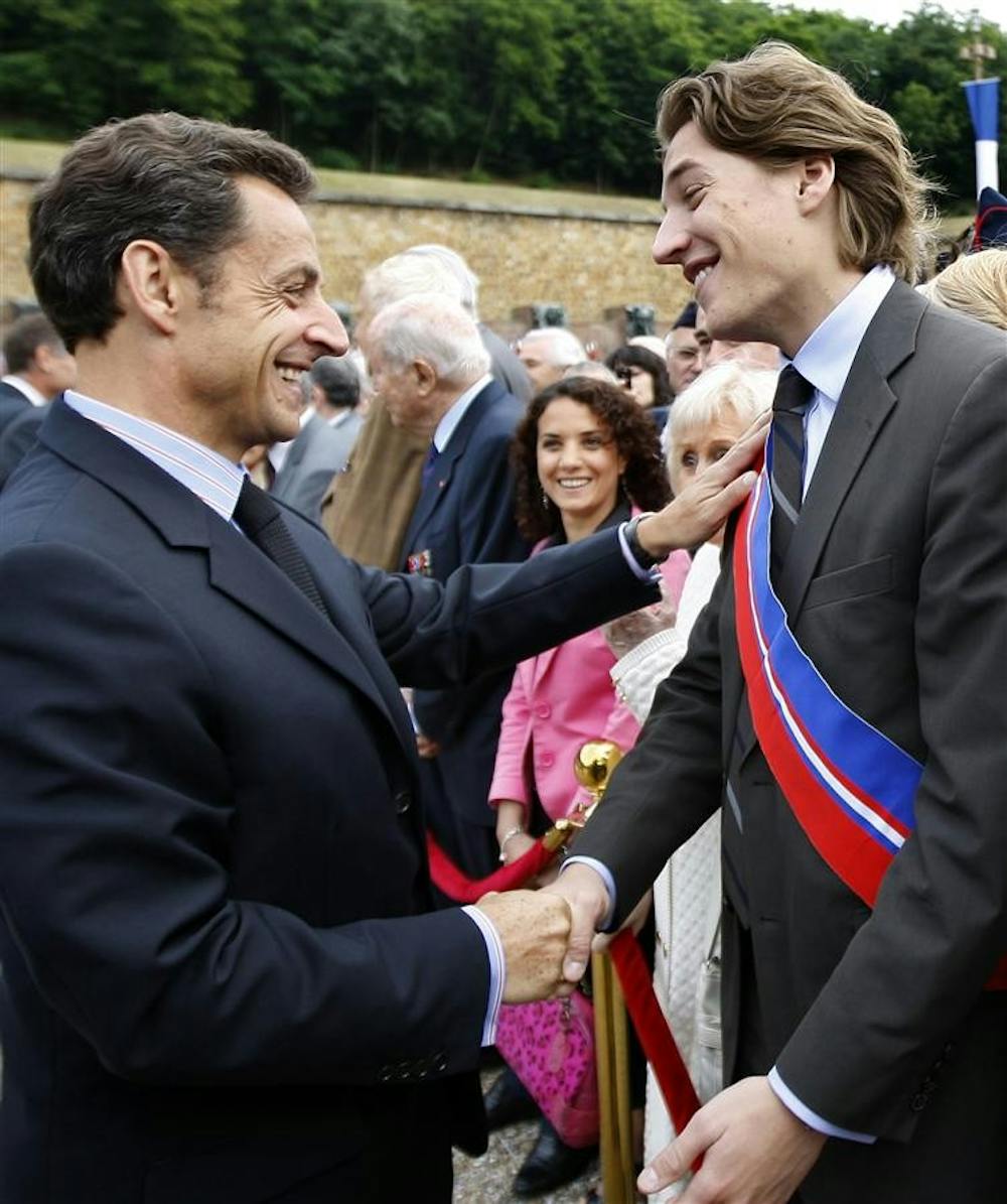 This June 18,photo shows French President Nicolas Sarkozy, left, shaking hands with his son Jean Sarkozy during a commemorative ceremony at the Mont Valerien memorial in Suresnes, west of Paris. Critics are questioning a bid by President Nicolas Sarkozy's 23-year-old son for a job overseeing France's premier business district. 