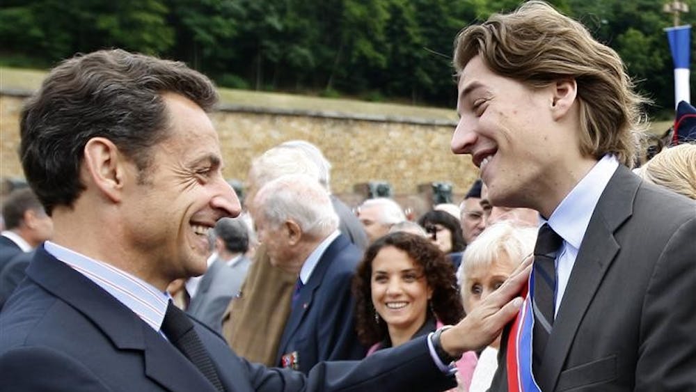 This June 18,photo shows French President Nicolas Sarkozy, left, shaking hands with his son Jean Sarkozy during a commemorative ceremony at the Mont Valerien memorial in Suresnes, west of Paris. Critics are questioning a bid by President Nicolas Sarkozy's 23-year-old son for a job overseeing France's premier business district. 