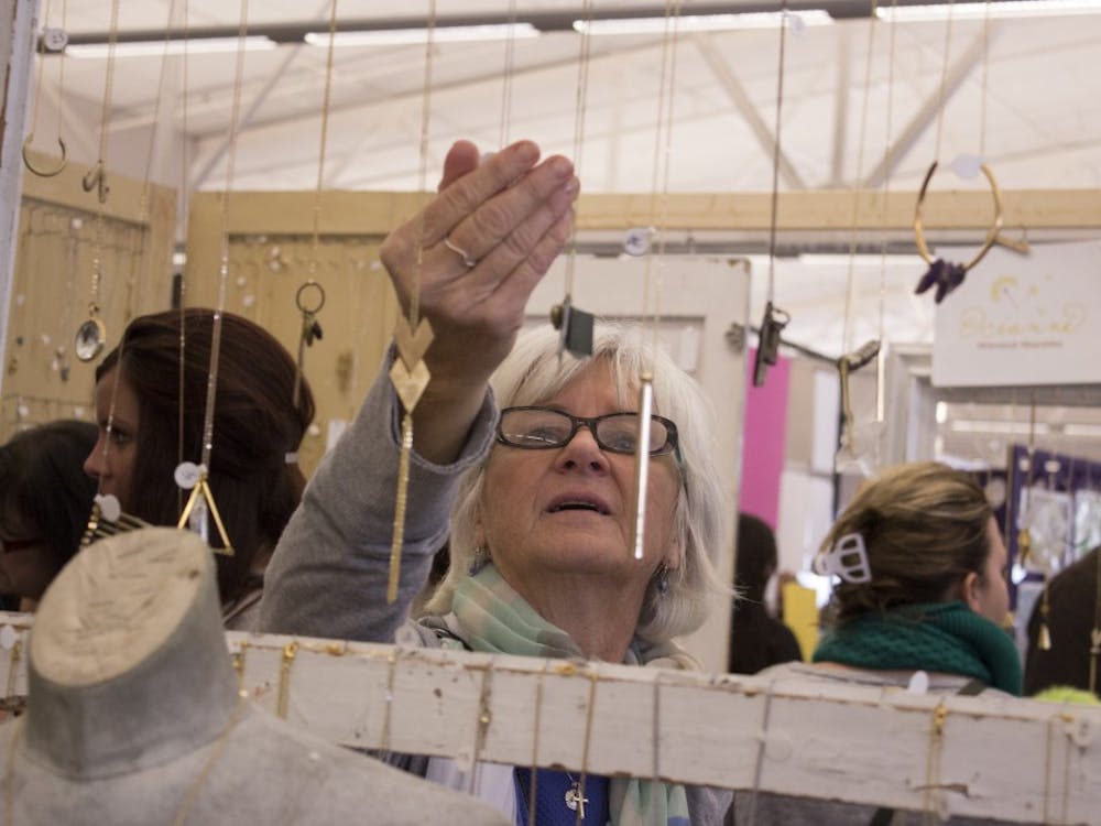 Bloomington resident Dawn Cartwright admires a necklace crafted by Anne Harrill on Nov. 8, 2013, at the Bloomington Handmade Market Saturday at the Convention Center. The market's 2019 holiday show will take place from 10 a.m. to 4 p.m. Nov. 9 at the Monroe Convention Center.