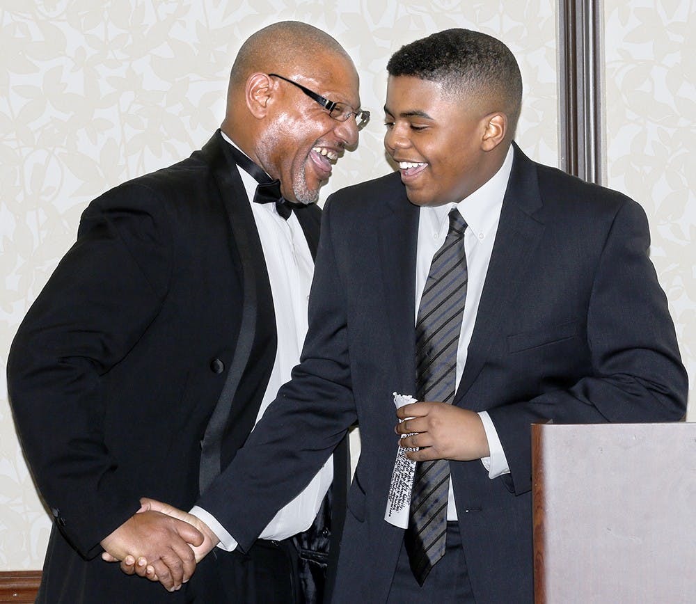 Dexter Charles Griffin, right, shakes hands with Cornelius Wright after receiving 2016 Outstanding Black Male Leader of Tomorrow High School Award Saturday at Hilton Garden Inn. Griffin is a freshman at Bloomington High School South. He received a 3.0 grade point average with involving the Theatre/Drama Club and "Sounds of South" premier performance choir. He also volunteers with WonderLab Museum of Science, Health & Technology during the summer. 