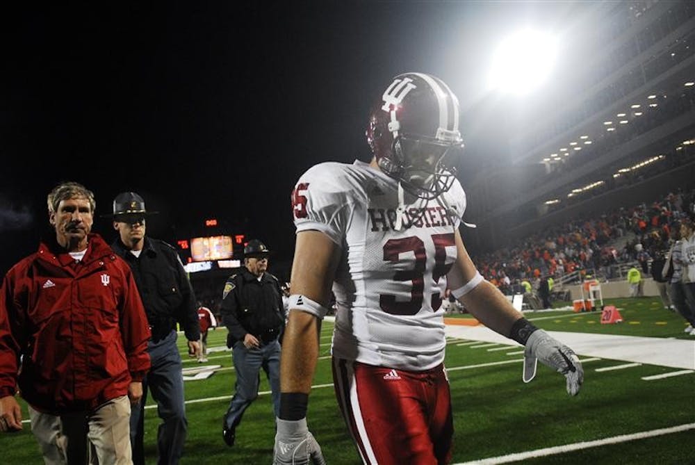 Defensive end Ryan Marando (right) and IU coach Bill Lynch (left) walk off the field Saturday at Memorial Stadium in Champaign, Ill. after a 55-13 defeat to the Fighting Illini. The loss was the fifth straight for the Hoosiers.