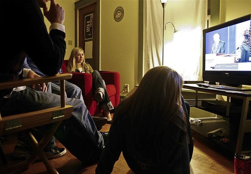 Senior Rose Byrne watches the debates with friends Thursday evening at a house on East University Street. Many different groups watched the debates across the city.