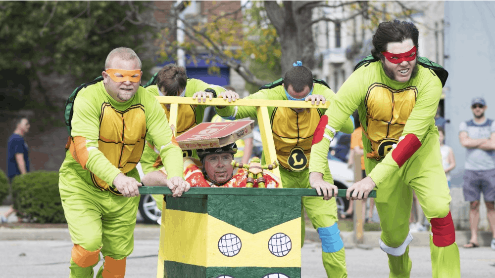 Team Turtle Power hurtles around the corner of the track during the final round of coffin races at the Updraft &amp; Campus Costume Coffin Races on Oct. 7. Turtle Power tied for first place with a time of 33.5 seconds before being voted the overall winner by applause from the audience.