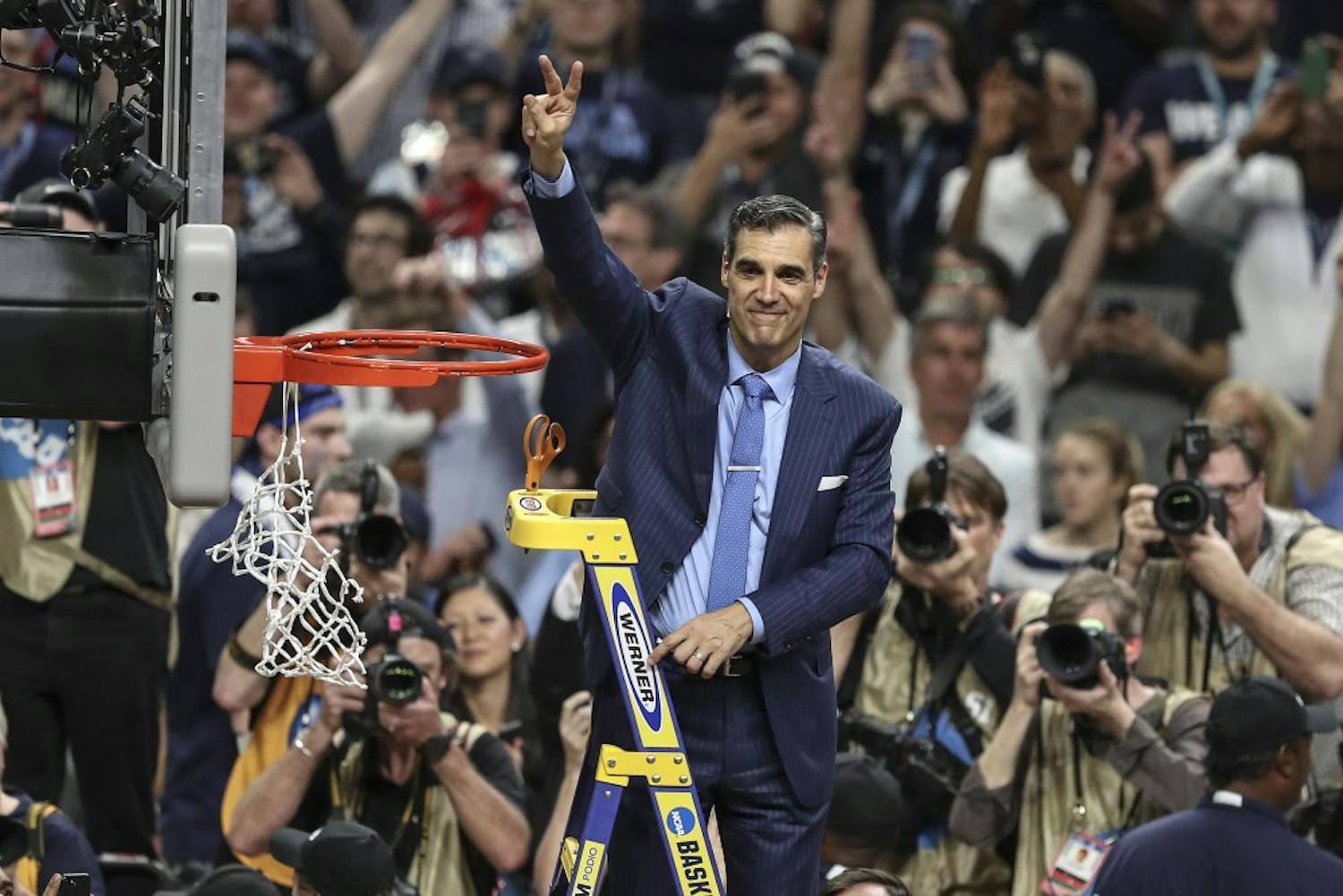 Villanova head coach Jay Wright waves the Villanova "V" to the fans while cutting the net after beating Michigan to win the NCAA National Championship on Monday, April 2, 2018, at the Alamodome in San Antonio, Texas. The Villanova team is the National Champion, beating Michigan 79-62.&nbsp;