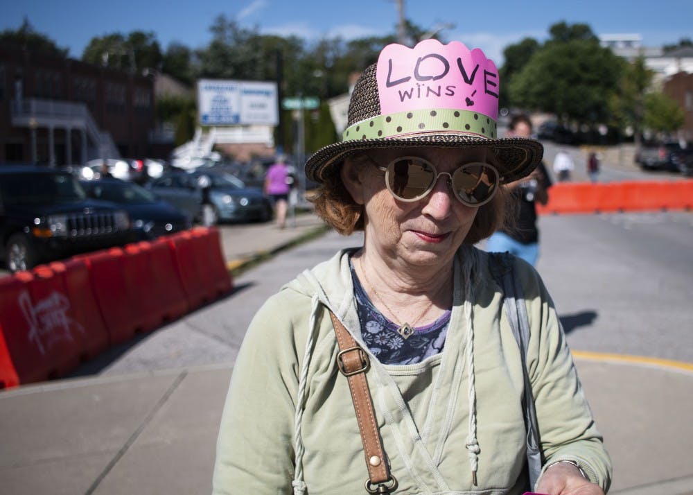 8月24日，在布卢明顿社区农贸市场，一位布卢明顿居民戴着一顶印有“爱获胜”字样的帽子。这名妇女过去一直对白人至上主义者经营的斯库纳克里克农场(Schooner Creek Farm)直言不讳。