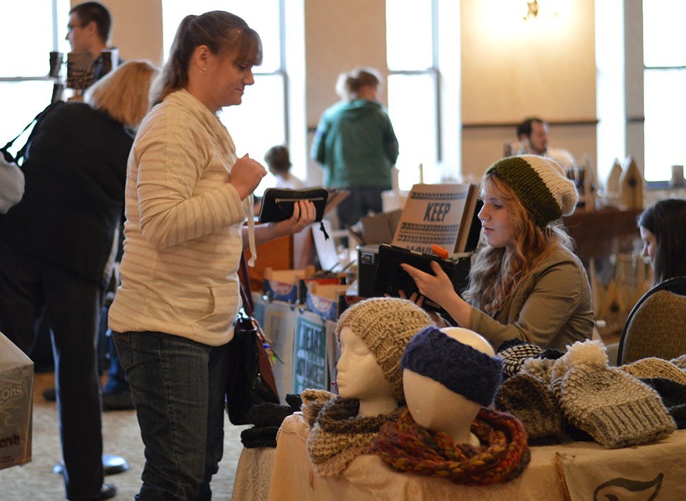 17-year-old Susannah Hall sells her knitted apparel at the Last Minute Gift Fair hosted by Gather Here on Sunday at the Fountain Square Mall. Hall's booth, called Zanna Knits, is made up entirely of items she made herself.