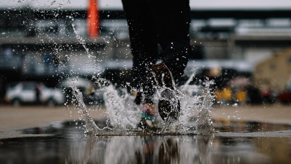 A photographer steps through a puddle in Gasoline Alley at the Indianapolis Motor Speedway May 16. Opening day for the Indianapolis 500 practice was rained out Tuesday. 