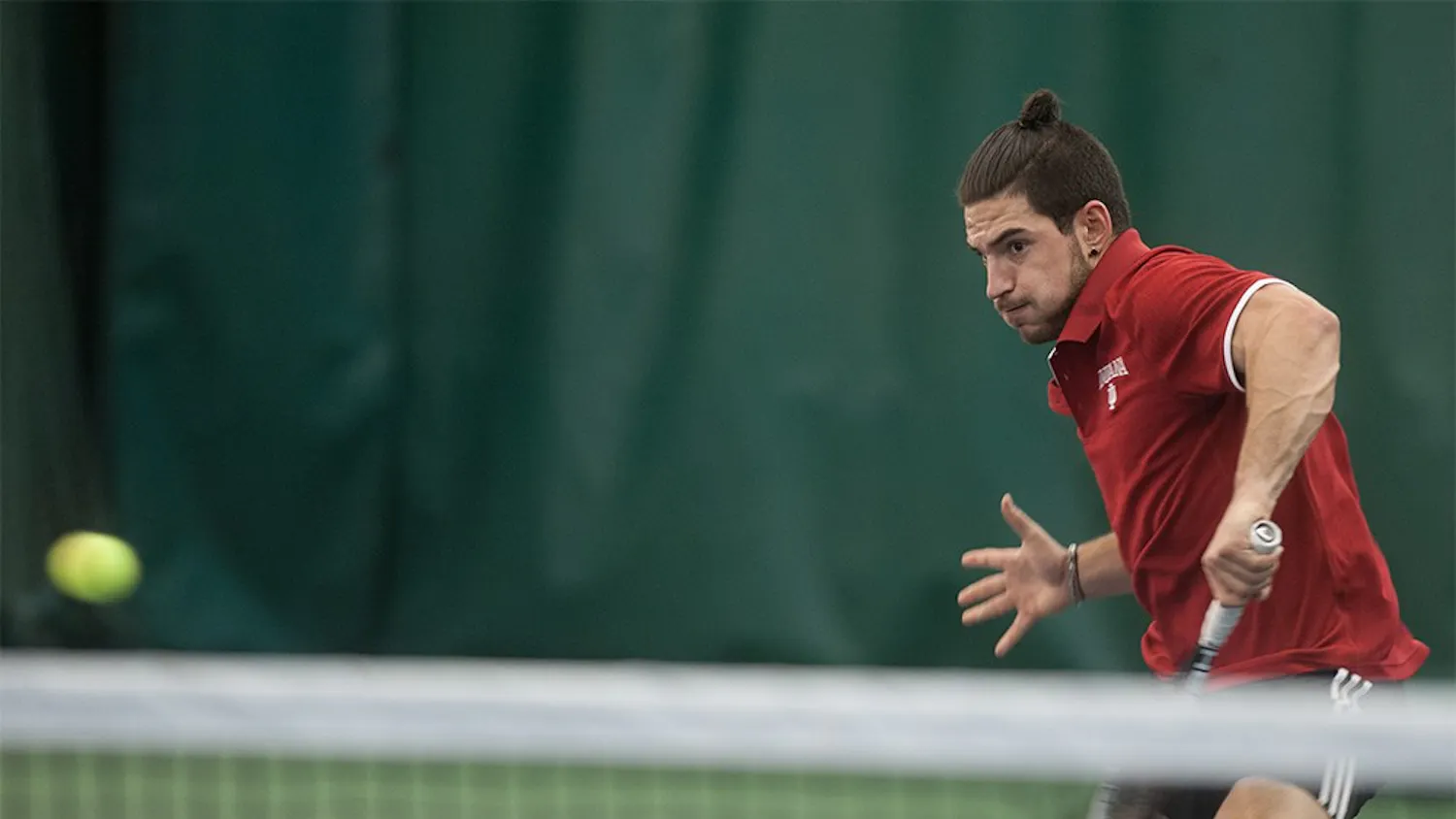 Sam Monette closing in to return with a volley against Sam Shropshire of Northwestern University on Friday at the IU Tennis Center. Monette lost the match 6-4, 7-5.
