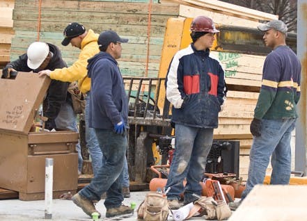 Workers look for chain to secure an air compressor at the Hutton Honors College construction site. Valuable tools that are not secured may be stolen.