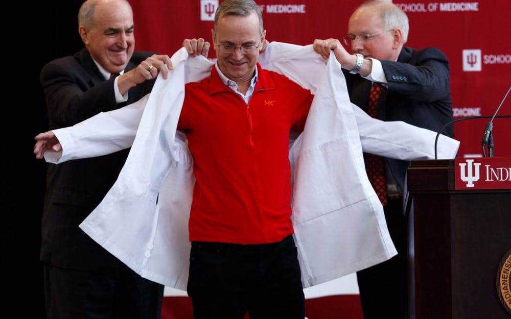 President Michael McRobbie and vice president and dean of the School of Medicine Jay Hess put a white coat on Dr. Don Brown. Brown recently donated $30 million to build a new immunotherapy center that will be named after himself.&nbsp;