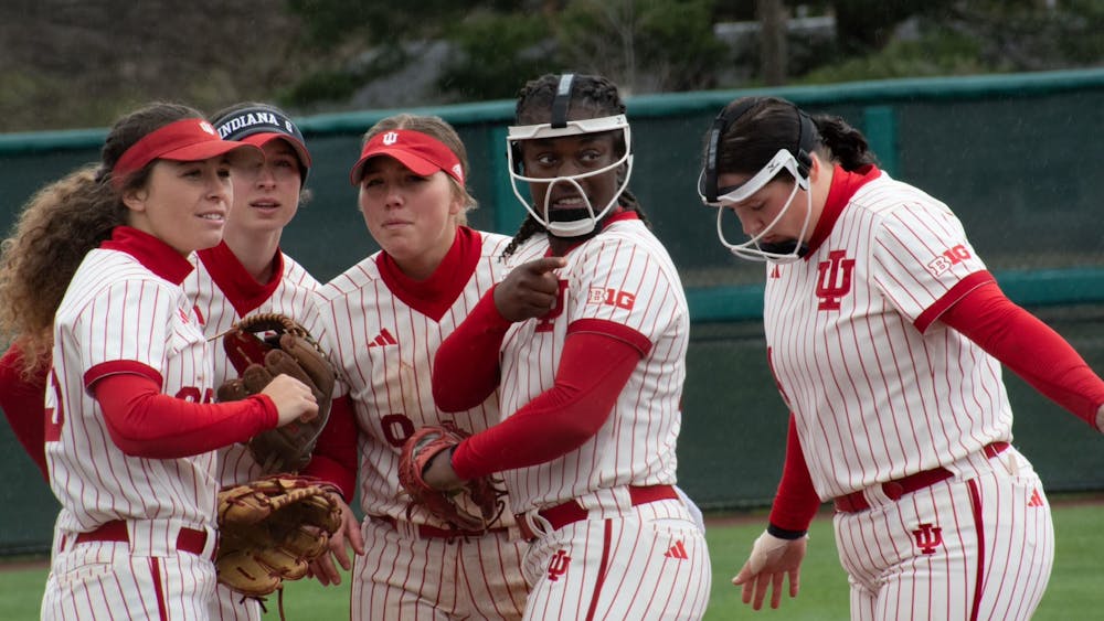 Members of the infield discuss before the game against the University of Maryland March 25, 2023, at Andy Mohr Field in Bloomington. Indiana softball&#x27;s Friday game against Ohio State was moved up two hours.