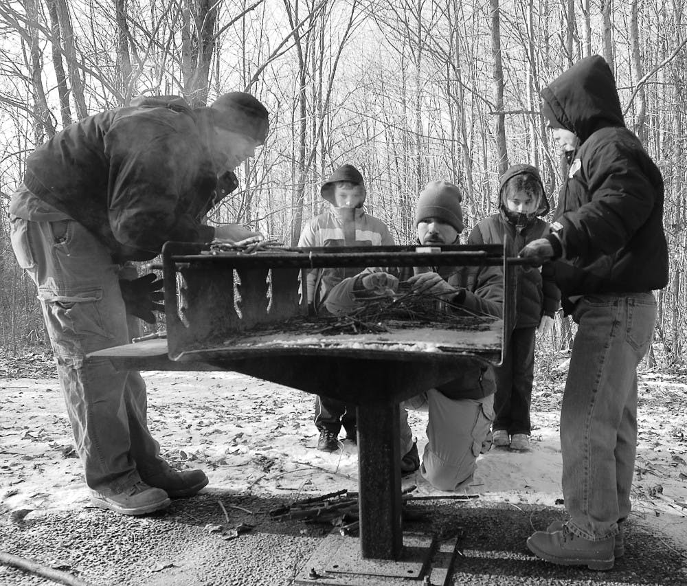 Participants attempt to build a fire during a class held by the Parks and Recreation Department.