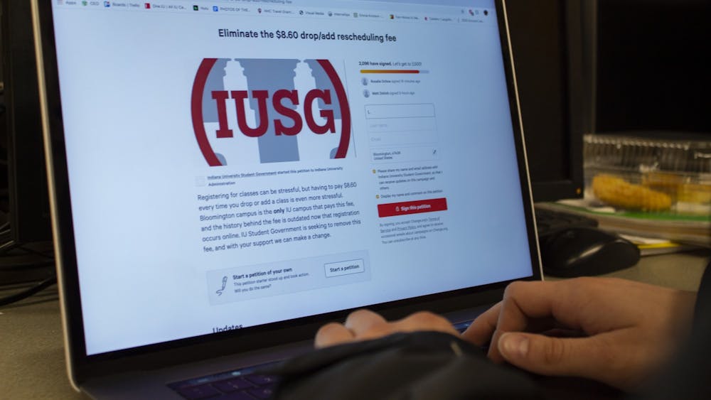 A student looks at a petition to eliminate the drop/add rescheduling fee. Indiana University Student Government started this petition in its efforts to eliminate the fee.