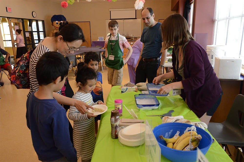 Alexandra Jia gets a fronzen fruit roll from the event staff at the WonderLab Museum of Science, Health and Technology during the Wonder Wonka Edible Chemistry program on Sunday May 10th. The apples and bananas used in activities were donated by Bloomingfoods.